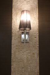 Elegant sconce lighting illuminates textured stone wall