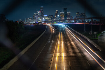 Houston downtown with car vehicle light tail on highway traffic to downtown district at night with skyscraper modern business office in center of Houston city in Texas, USA, United States of America  © Nantiya