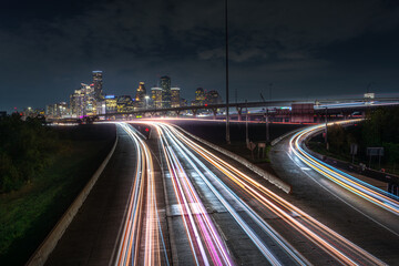 Houston downtown with car vehicle light tail on highway traffic to downtown district at night with skyscraper modern business office in center of Houston city in Texas, USA, United States of America 