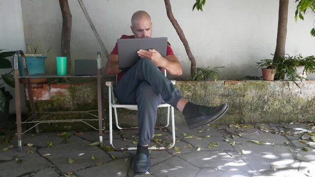 Home office: Man working on his laptop. Person typing on a computer. Someone uses a laptop at home. A man using a computer keyboard.