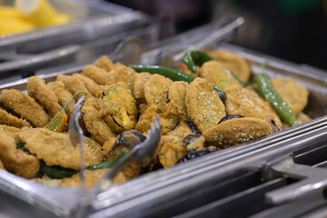 Savory fried snacks with peppers in a buffet tray