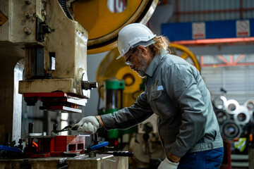 A man in a white helmet is working on a machine