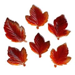 Obraz premium Red, translucent leaf candies scattered on a dark background