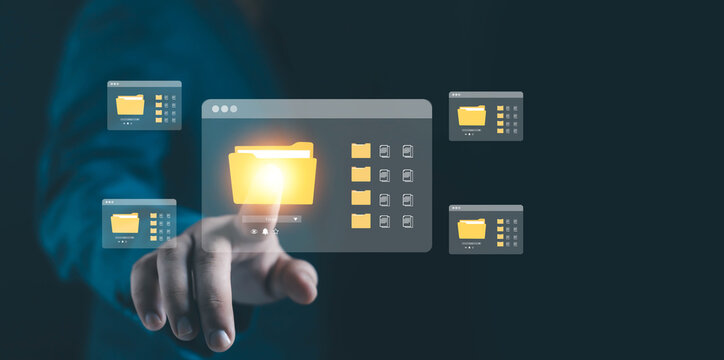 Businessman hand touching glowing digital folder icon on virtual screen, representing data management, cloud storage, file organization, technology network, and digital business concept. - Powered by Adobe