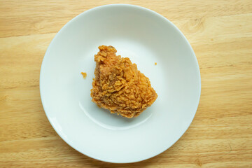 Crispy fried chicken thigh on white plate