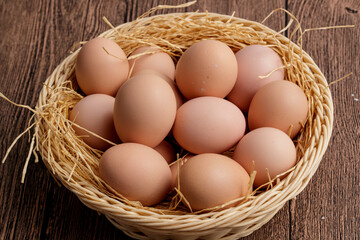 A bamboo basket with a wooden background is filled with delicious fried eggs.