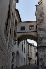 Fototapeta premium Stone archway between historic buildings in narrow street view