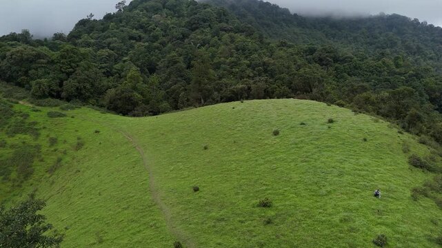 Beautiful rolling hills of native grasses and trees during a drought with clouds in the sky