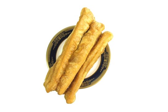 Fried bread or cakwe isolated on a white background. Also known as Youtiao or Cakoi, this food is very popular among Chinese, Indonesian, Malaysian, and Singaporean people as a breakfast dish.
