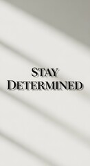 Inspirational message with the words 'Stay Determined' displayed on a minimalistic background with shadows for motivation and encouragement