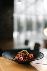 Vibrant beetroot salad served in deep black plate, healthy vegetarian meal