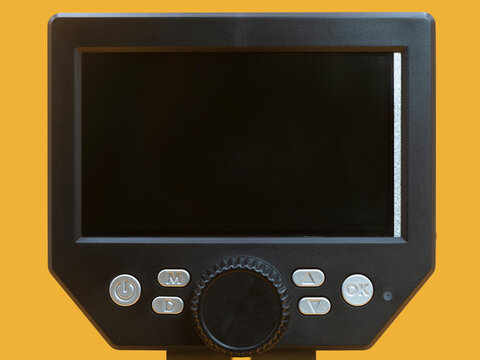 Close-up view of a digital microscope monitor showing control buttons and screen interface, representing precision laboratory technology, scientific equipment and innovation in digital research tools.
