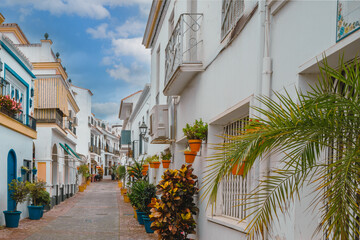 Breathtakingly beautiful street in Costa del Sol, Spain, lined with planters and shrubs on a sunny Spring day.