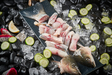Arrange the glistening, white slices of fresh fish on a black round porcelain plate.