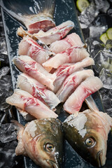 Arrange the glistening, white slices of fresh fish on a black round porcelain plate.