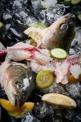 Arrange the glistening, white slices of fresh fish on a black round porcelain plate.