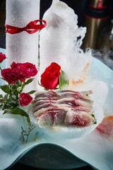 Arrange the glistening, white slices of fresh fish on a black round porcelain plate.