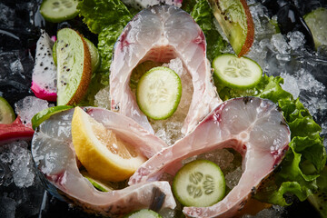 Arrange the glistening, white slices of fresh fish on a black round porcelain plate.
