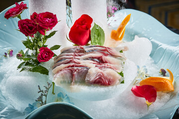 Arrange the glistening, white slices of fresh fish on a black round porcelain plate.