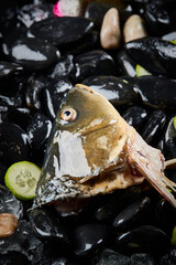Arrange the glistening, white slices of fresh fish on a black round porcelain plate.