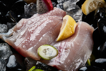 Arrange the glistening, white slices of fresh fish on a black round porcelain plate.