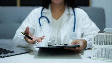 Healthcare professional doctor writing medical records on a clipboard. Female unrecognizable physician at work. Medicine and pharmacy
