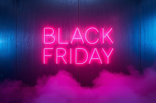 Vibrant pink neon sign glowing with the words black friday against a dark textured wall with atmospheric smoke and blue lighting