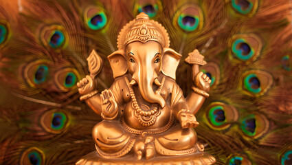 Ganesha idol with peacock feathers as a backdrop