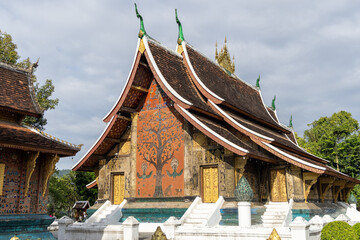 Fototapeta premium An important Buddhist monastery and symbol of the UNESCO World Heritage town of Luang Prabang, featuring the distinctive low-sweeping tiered roofs.