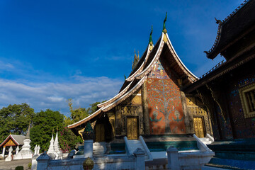 Fototapeta premium An important Buddhist monastery and symbol of the UNESCO World Heritage town of Luang Prabang, featuring the distinctive low-sweeping tiered roofs.