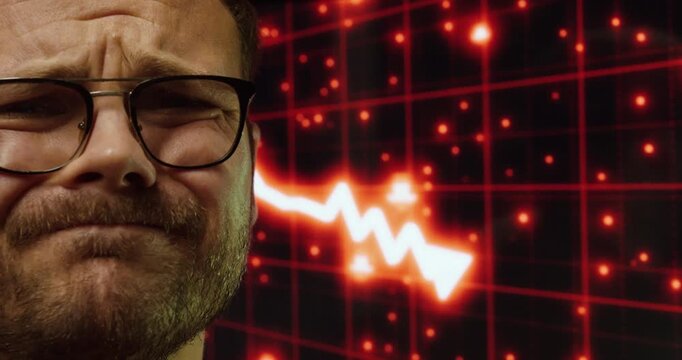 Close-up of a worried man reacting to a market crash shown on a digital screen. Concept of economic crisis, financial loss, and emotional stress in trading.