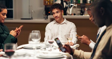 Man, bored and group at restaurant with phone addiction, social isolation and annoyed at dinner. Person, friends and smartphone with mobile app, chat and bad manners with frustrated thinking at diner