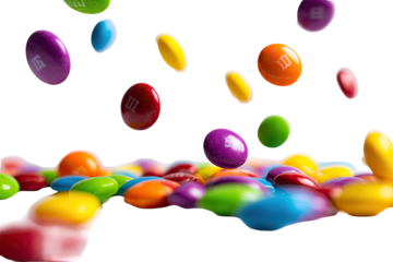 A close-up of colorful, candy-coated chocolate pieces, some falling, on a black background