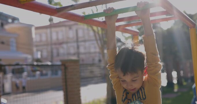Young boy drops of monkey bars half way across
