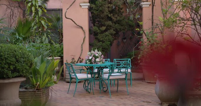 Isolated patio table and chairs with vibrate flowers and plants