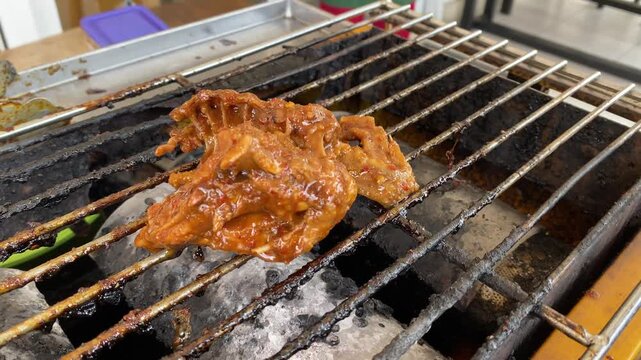 Juicy chicken leg sizzling on smoky bbq grill