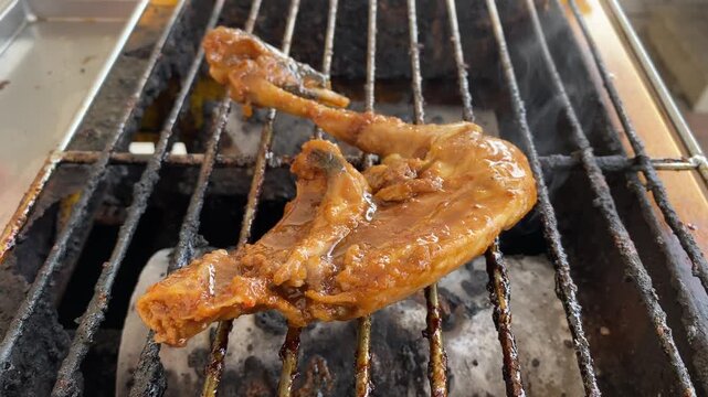 Juicy chicken leg sizzling on smoky bbq grill