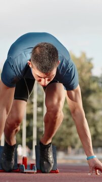 athlete sprinter starting run on stadium vertical slow motion fullHD early morning light motivation power discipline determination speed focus strength healthy lifestyle inspiration