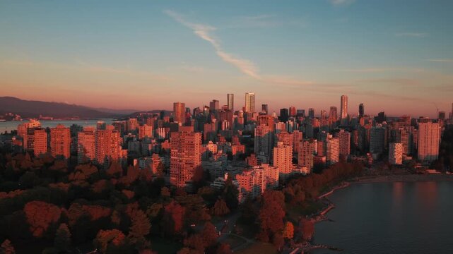 Aerial wide panning shot of English Bay at sunset on a clear evening in downtown Vancouver, British Columbia, Canada. 4K