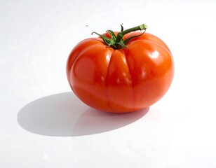 Close-up of a perfectly ripe, red tomato with green stem