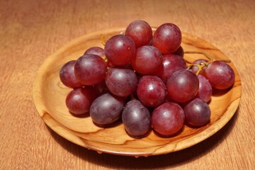 red grapes on a wooden plate