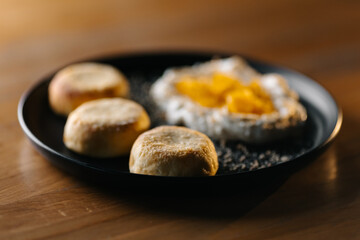 Traditional dumplings with sour cream and fried onions on wooden plate