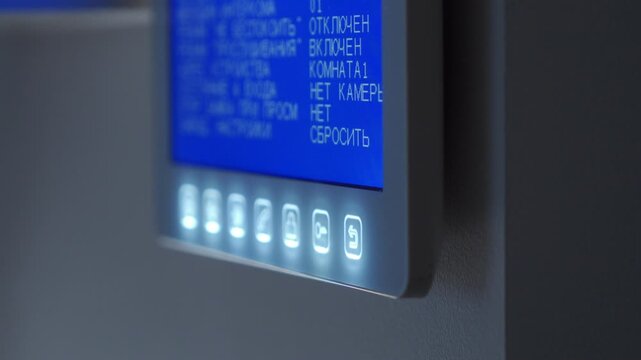An apartment intercom system rings, its screen and buttons glowing in the dark. The device chimes with a loud ding-dong sound.