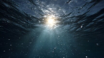 Fototapeta premium Sunlight beams penetrate the ocean s surface casting luminous rays into the deep water and illuminating floating bubbles