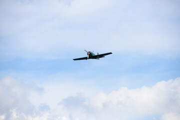 Single-Engine Aircraft Flying in Blue Sky with White Clouds