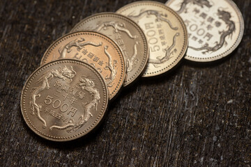 500 yen dragon coins on rustic wood. Ideal for finance, fantasy, gaming, and currencythemed designs needing an asian touch. © Mr