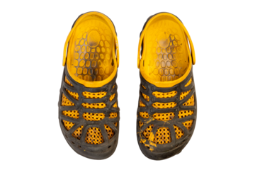 dirty paint stained and heavily worn yellow black rubber sandals or shoes with perforated design, top view