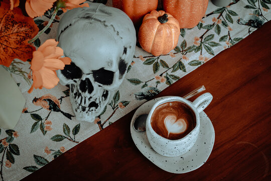 Halloween celebrated coffee,Close up of Hot coffee latte with latte art milk foam in cup mug with decor in a coffee a theme of halloween on wood desk Halloween holiday background. - Powered by Adobe