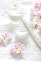 cream and spa on wooden background with flowers