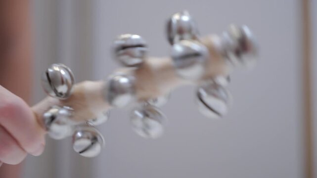 Crisp Percussion: Hand Shakes Wooden Rattle with Jingle Bells.